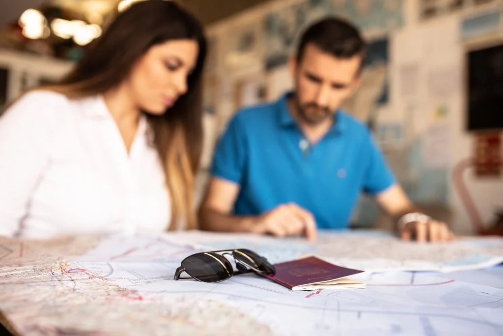 pareja revisando mapa gafas pasaporte